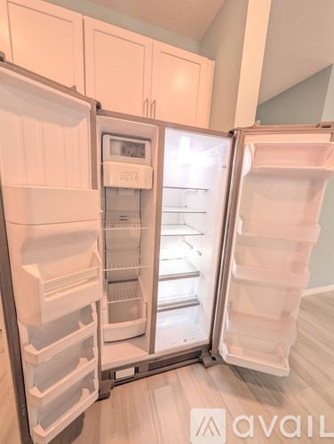 A white refrigerator with its door open in a kitchen.