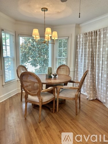 A dining room with a round table and chairs.