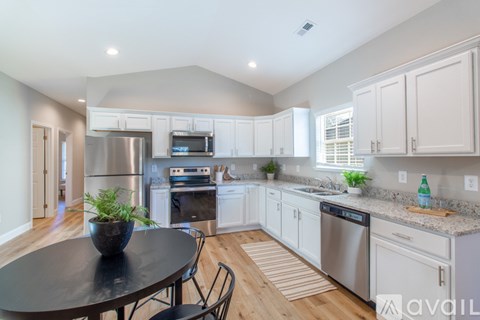A kitchen with white cabinets and a black table.