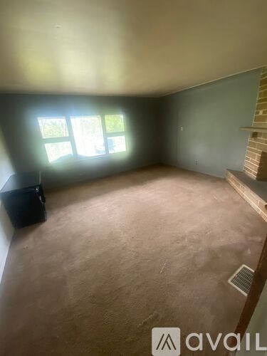 A room with a window and a wall-mounted shelf.