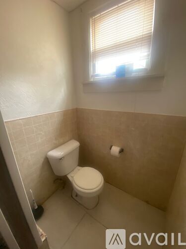A small bathroom with a toilet and a window.