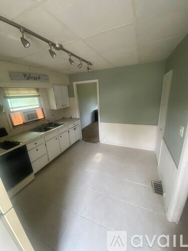 A kitchen with white cabinets and a black dishwasher.