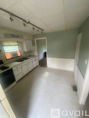 A kitchen with white cabinets and a black dishwasher.