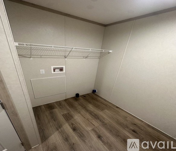 A small, empty room with a white door and a white shelf.