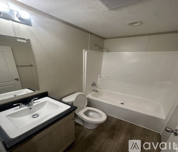 A bathroom with a toilet, sink, and bathtub.