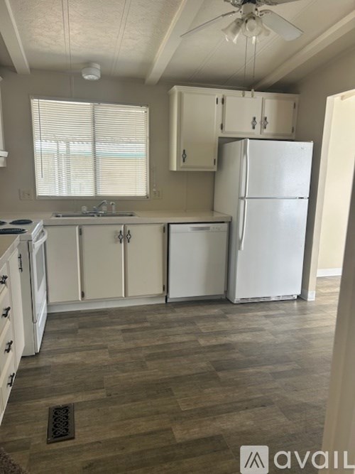 A kitchen with white appliances and cabinets.