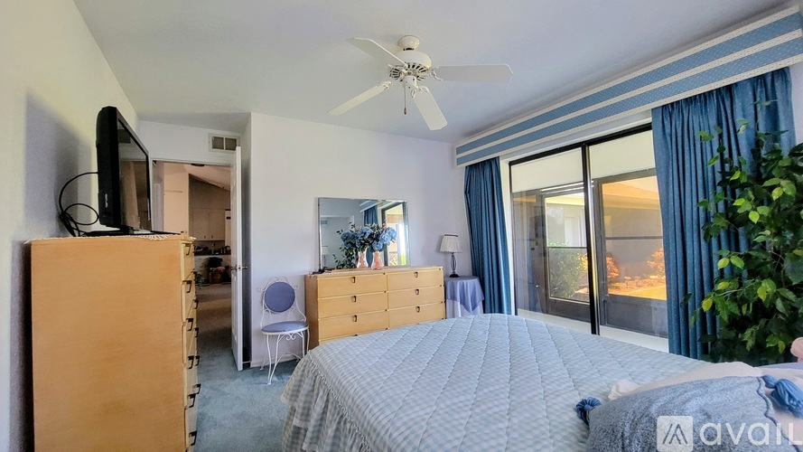 A bedroom with a large bed and a ceiling fan.