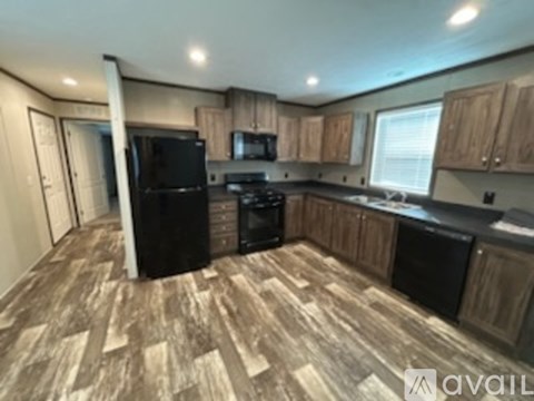 A kitchen with black appliances and wooden cabinets.