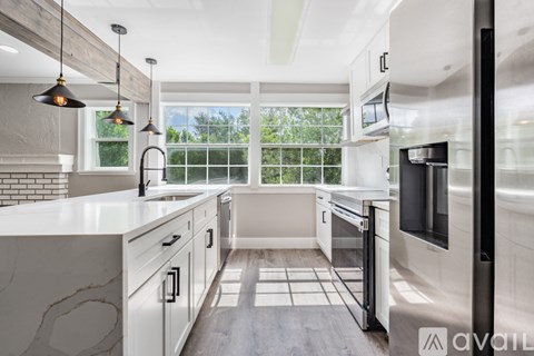 A modern kitchen with white cabinets and a large island.