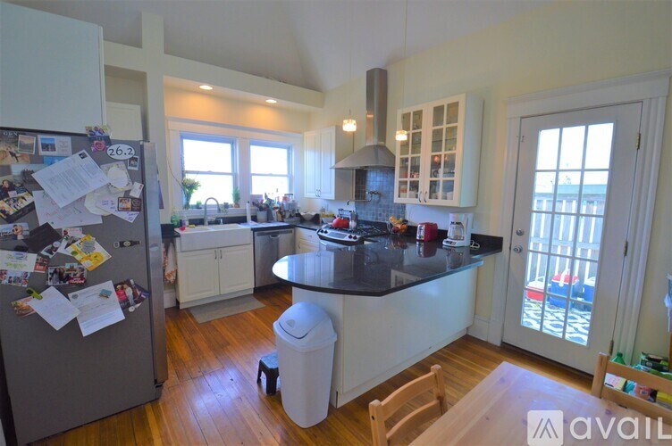 A kitchen with a refrigerator covered in papers.