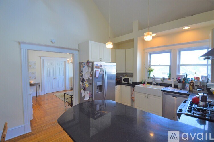 A kitchen with a black countertop and white cabinets.