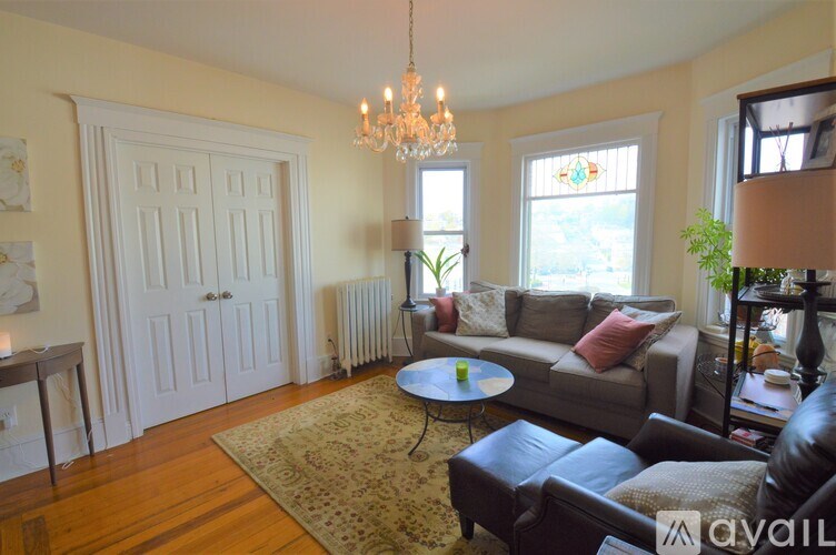 A living room with a couch, chairs, and a rug.