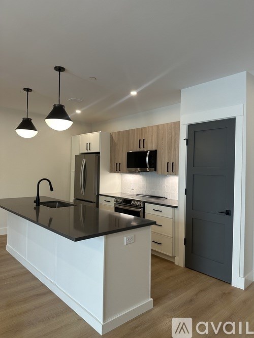 A kitchen with a black countertop and white cabinets.