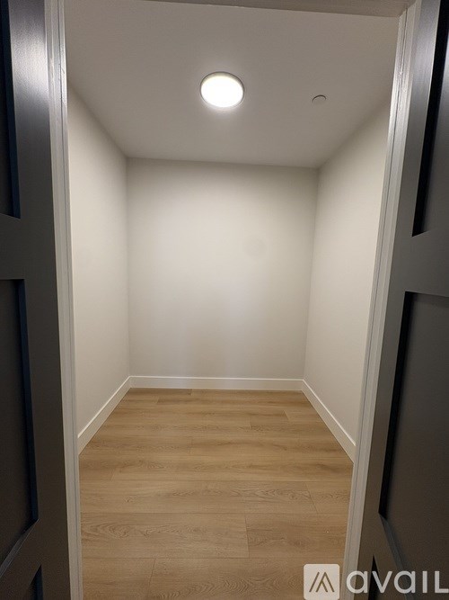 A hallway with wooden floors and white walls.