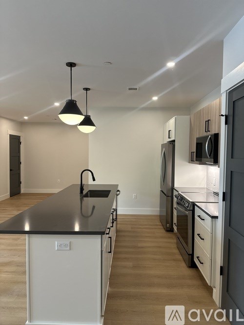 A kitchen with black countertops and white cabinets.
