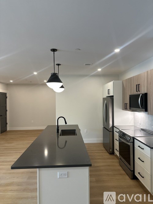 A kitchen with a black countertop and white cabinets.
