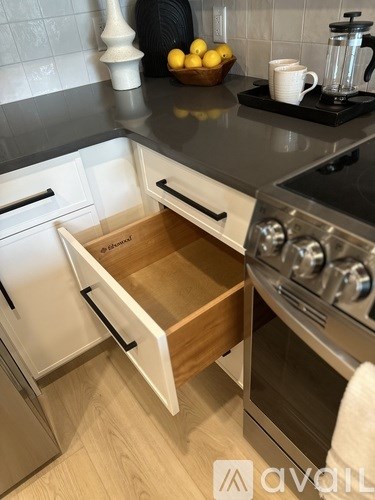 A modern kitchen with a stove top oven and a drawer underneath it.