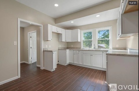 A kitchen with white cabinets and a window.