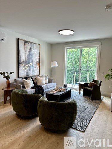 A living room with a grey sofa, a coffee table, and a large painting on the wall.
