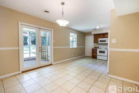 A kitchen area with a white oven and microwave, and a dining area with a table and chairs.