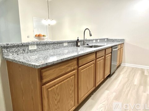 A kitchen with wooden cabinets and a granite countertop.