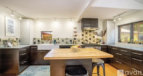 A kitchen with a wooden table and chairs, and a sink with a faucet.