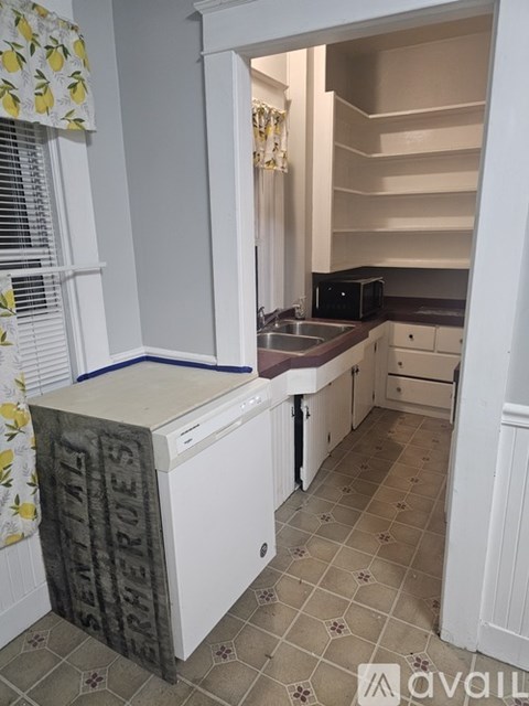 A kitchen with a white fridge and a sink.