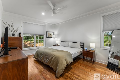 A bedroom with a large bed and a ceiling fan.