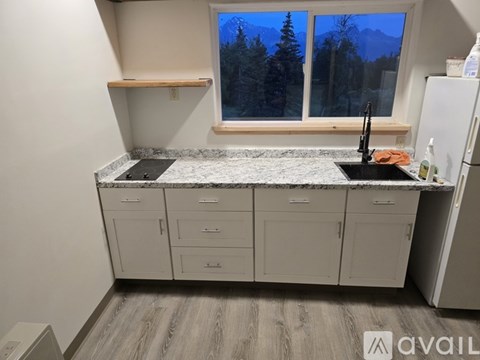 A kitchen with a marble countertop and wooden flooring.