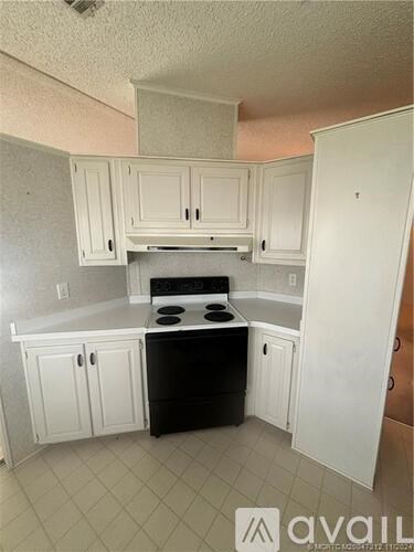 A kitchen with white cabinets and a black stove top oven.