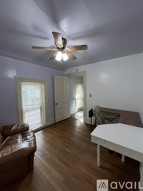 A living room with a brown leather couch and a white table.