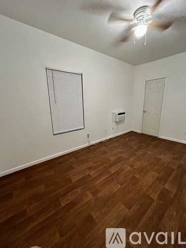 A room with wooden flooring and a ceiling fan.