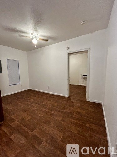 A room with wooden flooring and a ceiling fan.