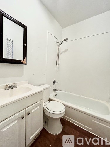 A white bathroom with a toilet, sink, and tub.