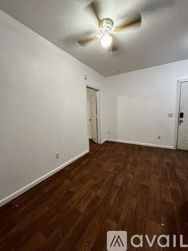 A room with wooden floors and a ceiling fan.