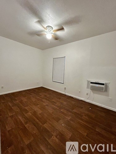 A room with wooden flooring and a ceiling fan.