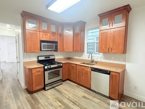 A kitchen with wooden cabinets and a stove top oven.