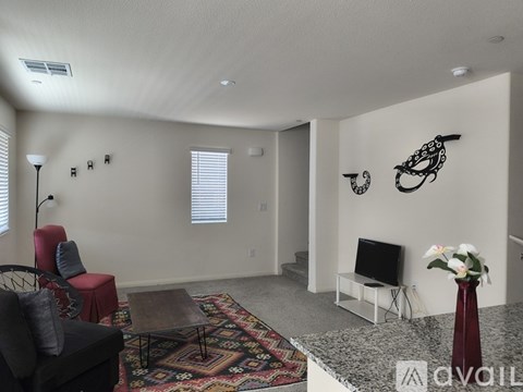 A living room with a red chair and a black couch.