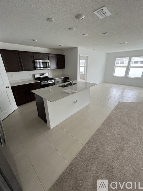 A kitchen with dark brown cabinets and a white island.