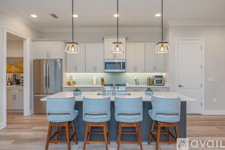 A kitchen with a bar and chairs.