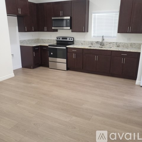 A kitchen with brown cabinets and a stove top oven.