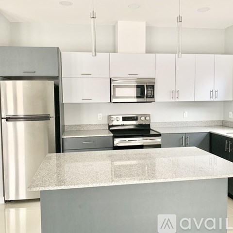 A kitchen with a refrigerator, microwave, oven, and stove.
