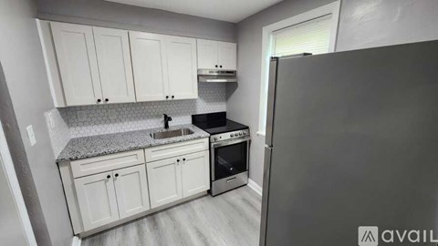 A kitchen with white cabinets and a granite countertop.