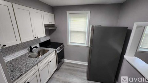 A kitchen with a black fridge and a sink.