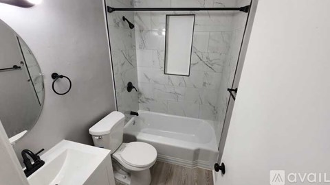 A bathroom with a toilet, sink, and shower.