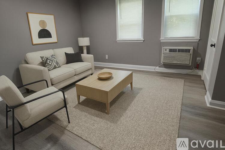 A spacious room with grey walls and a wooden floor.