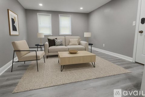 A living room with a beige sofa, two chairs, and a coffee table.