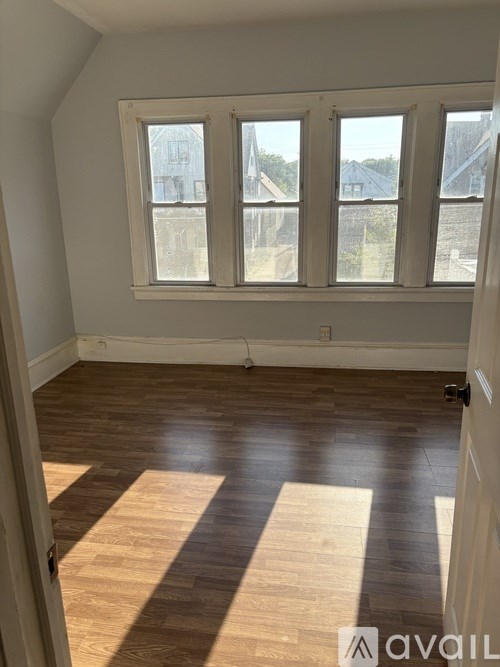 A room with wooden flooring and a large window.