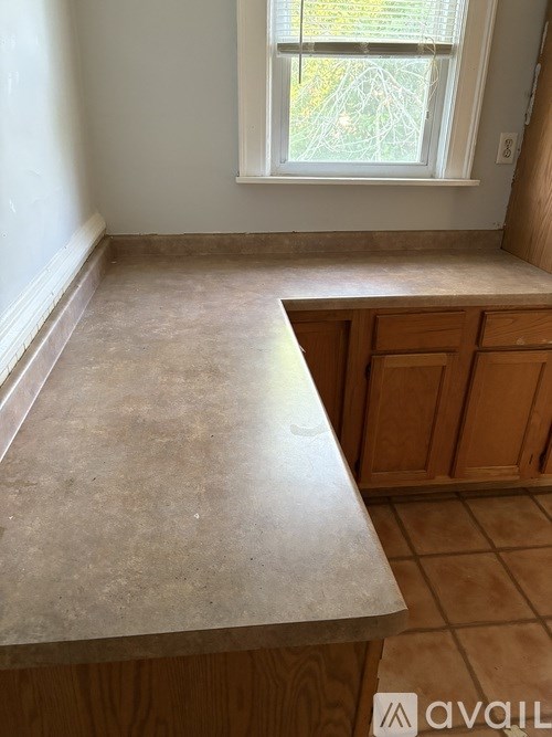 A kitchen countertop with a window above it.