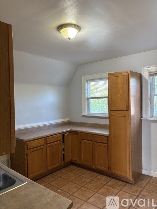 A kitchen with wooden cabinets and a window.